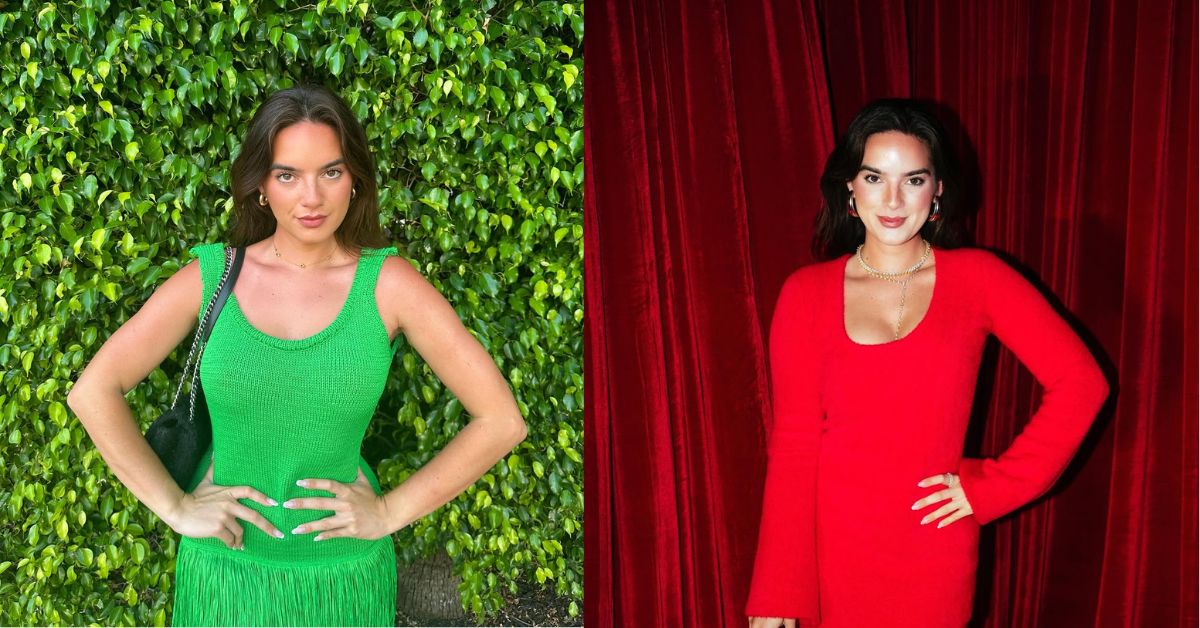 A person in a green dress posing in front of a hedge